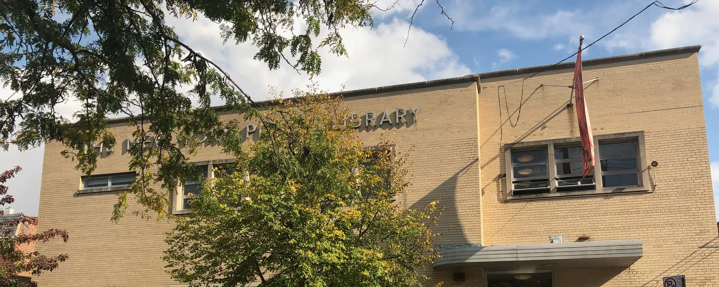 The Allerton branch of the New York Public Library on Barnes Avenue, with a tree in front